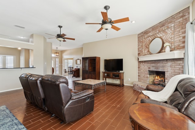 living room with dark hardwood / wood-style floors, a fireplace, and ceiling fan with notable chandelier