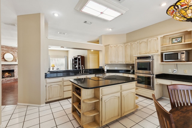 kitchen featuring light tile patterned flooring, appliances with stainless steel finishes, a center island, and sink