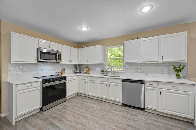 kitchen featuring white cabinets, light hardwood / wood-style floors, sink, and stainless steel appliances