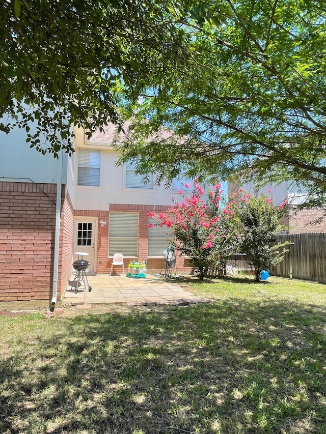 rear view of property with a yard and a patio