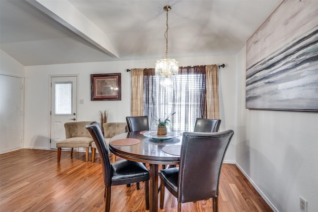 dining space with wood-type flooring and an inviting chandelier