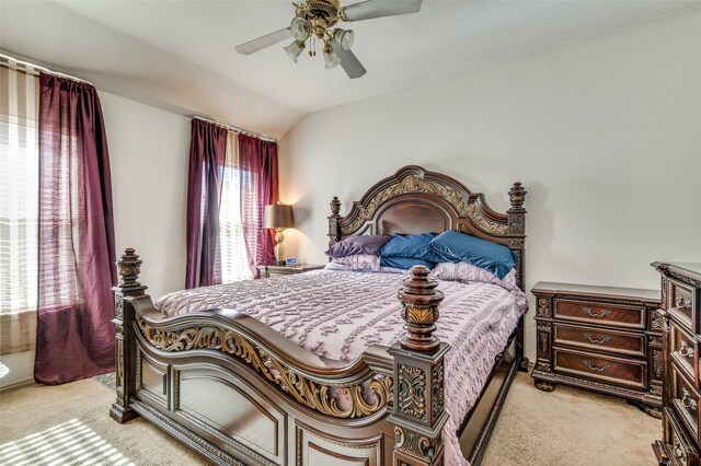 bedroom with ceiling fan, light colored carpet, and vaulted ceiling