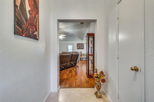 corridor featuring light wood-type flooring and lofted ceiling