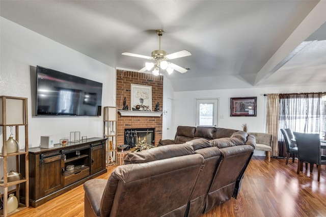 living room featuring a fireplace, wood-type flooring, and ceiling fan