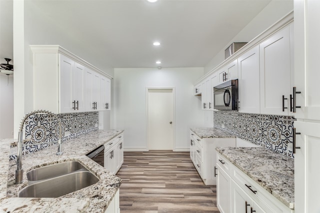 kitchen featuring backsplash, white cabinetry, sink, and light hardwood / wood-style flooring