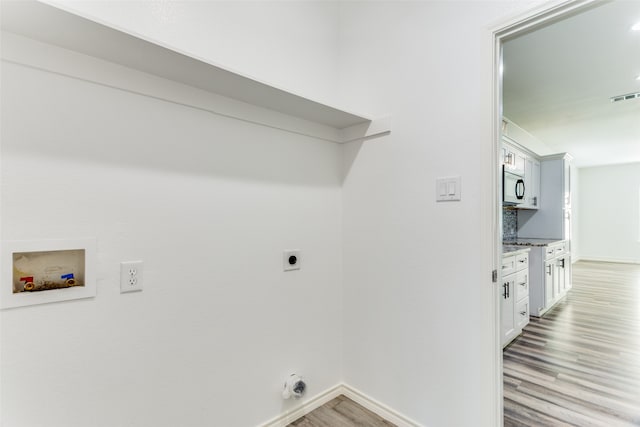 clothes washing area featuring washer hookup, electric dryer hookup, and light hardwood / wood-style flooring