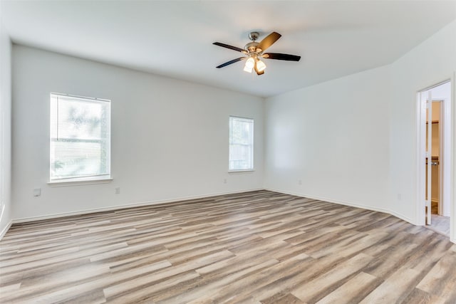 empty room with light hardwood / wood-style flooring, plenty of natural light, and ceiling fan