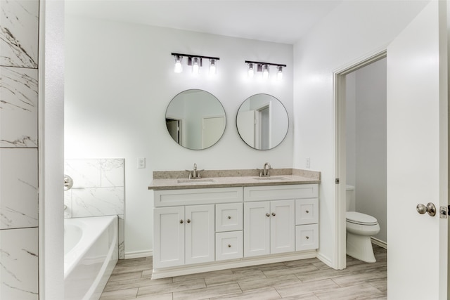 bathroom with hardwood / wood-style flooring, vanity, a bath, and toilet