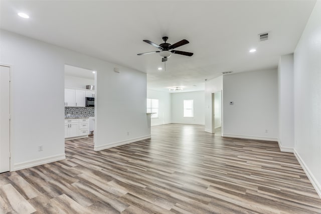 unfurnished living room featuring ceiling fan and light hardwood / wood-style flooring