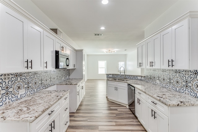 kitchen with sink, decorative backsplash, light wood-type flooring, appliances with stainless steel finishes, and white cabinetry