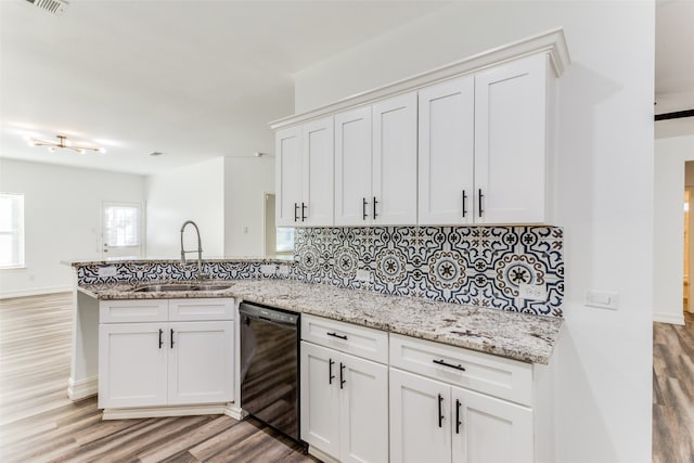 kitchen featuring white cabinets, dishwasher, light wood-type flooring, and decorative backsplash