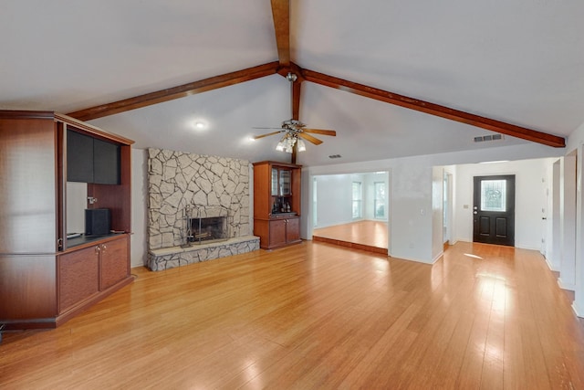 unfurnished living room featuring lofted ceiling with beams, ceiling fan, light wood-type flooring, and a fireplace