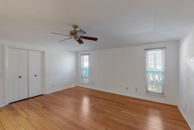 unfurnished bedroom with ceiling fan and light wood-type flooring