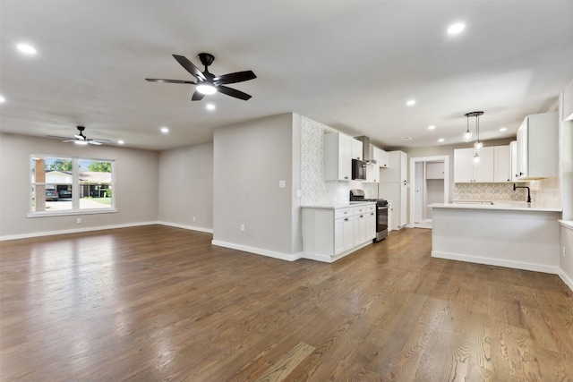 unfurnished living room with dark hardwood / wood-style flooring, ceiling fan, and sink