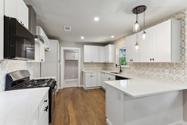 kitchen with dark wood-type flooring, sink, black appliances, white cabinets, and hanging light fixtures