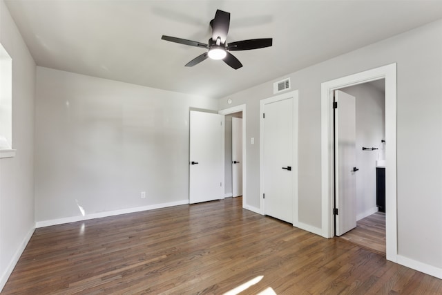 unfurnished bedroom with ceiling fan and dark hardwood / wood-style flooring