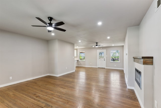 unfurnished living room with hardwood / wood-style floors and ceiling fan