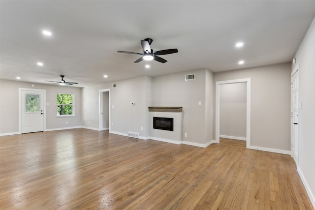 unfurnished living room featuring ceiling fan and light hardwood / wood-style floors