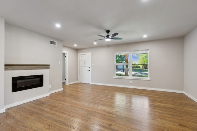 unfurnished living room featuring ceiling fan and light hardwood / wood-style floors