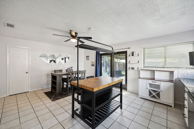 dining room with light tile patterned floors, visible vents, a textured ceiling, and ceiling fan