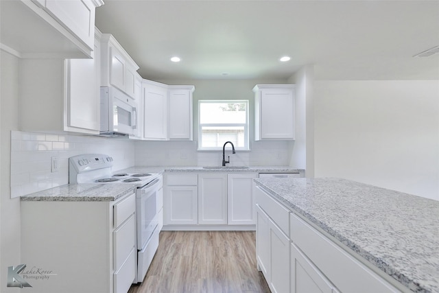 kitchen featuring white cabinets, light wood-type flooring, white appliances, and sink