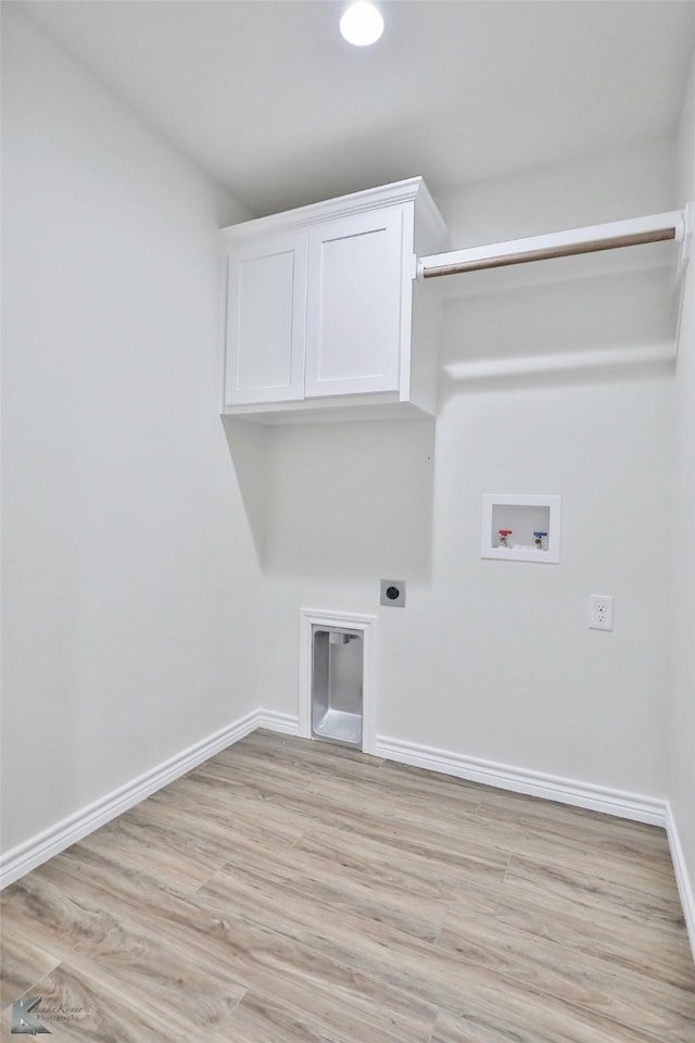 laundry room with hookup for an electric dryer, cabinets, light hardwood / wood-style floors, and washer hookup