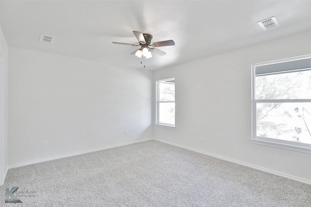 unfurnished room with carpet flooring, ceiling fan, and a healthy amount of sunlight