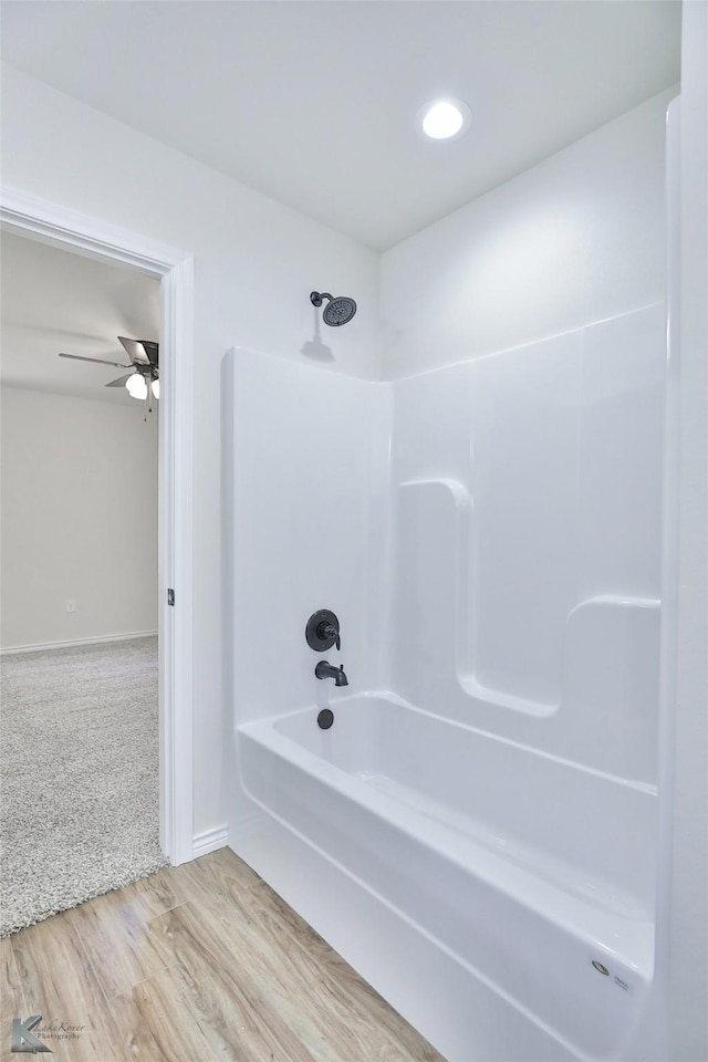 bathroom with wood-type flooring and shower / tub combination