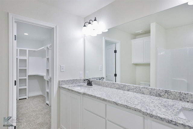 bathroom with vanity, toilet, and a shower