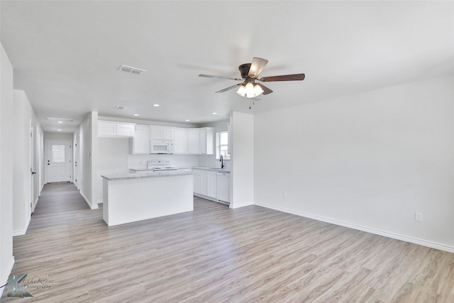 kitchen featuring white cabinetry, light hardwood / wood-style flooring, and white appliances