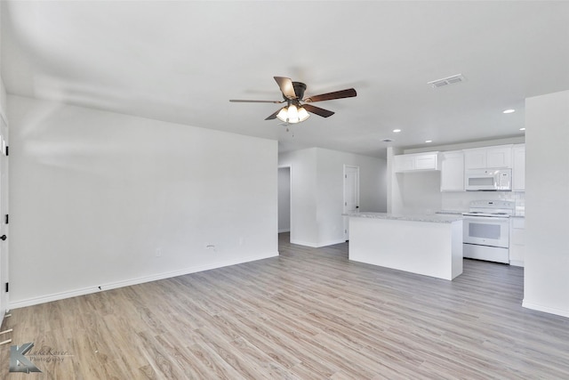 unfurnished living room featuring ceiling fan and light hardwood / wood-style flooring