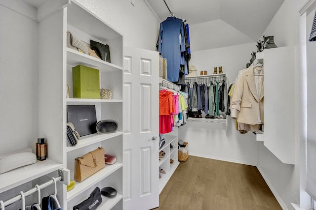 spacious closet with wood-type flooring and vaulted ceiling