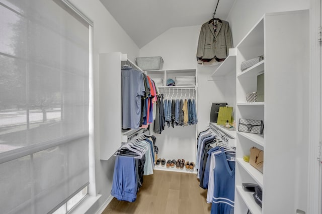 walk in closet featuring vaulted ceiling and light hardwood / wood-style flooring