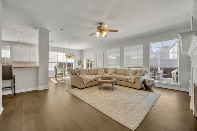 living room featuring wood-type flooring, decorative columns, and ceiling fan