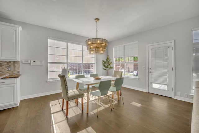 dining area featuring dark hardwood / wood-style flooring and an inviting chandelier