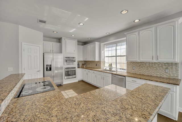 kitchen with tasteful backsplash, white cabinetry, sink, and appliances with stainless steel finishes