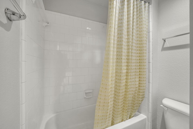 bathroom with shower / bath combination with curtain and toilet