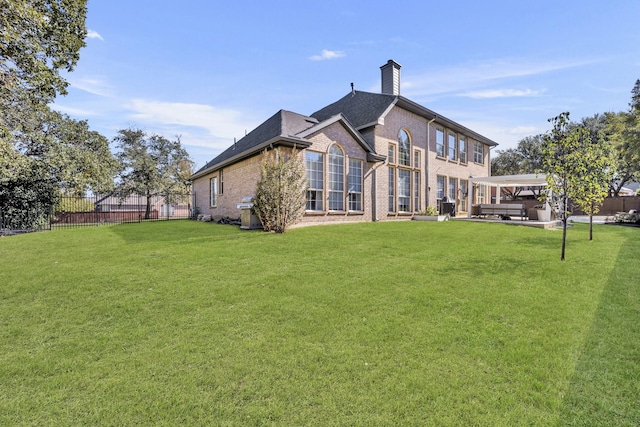 rear view of house featuring a yard