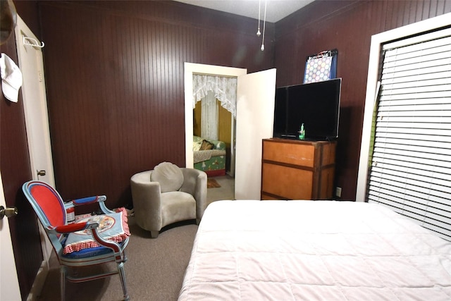 bedroom featuring carpet flooring and wooden walls