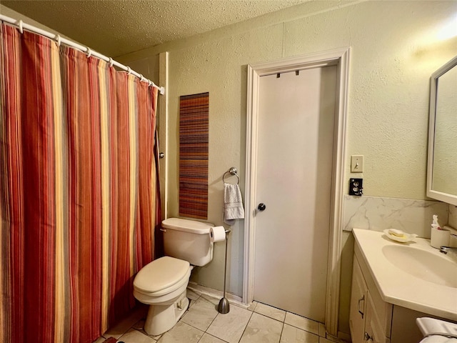 bathroom with a textured wall, toilet, tile patterned floors, a textured ceiling, and vanity