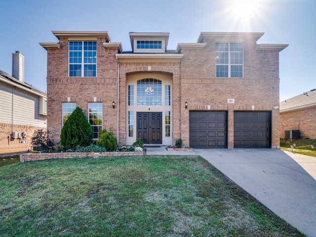 view of front facade with central AC unit, a front yard, and a garage