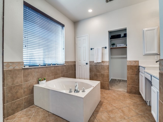 bathroom featuring tile patterned flooring, vanity, and tile walls