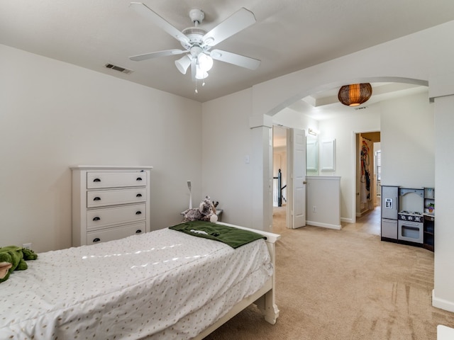 bedroom with a spacious closet, ceiling fan, and light colored carpet