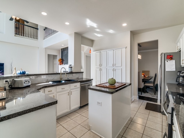 kitchen featuring white cabinets, a kitchen island, sink, and appliances with stainless steel finishes