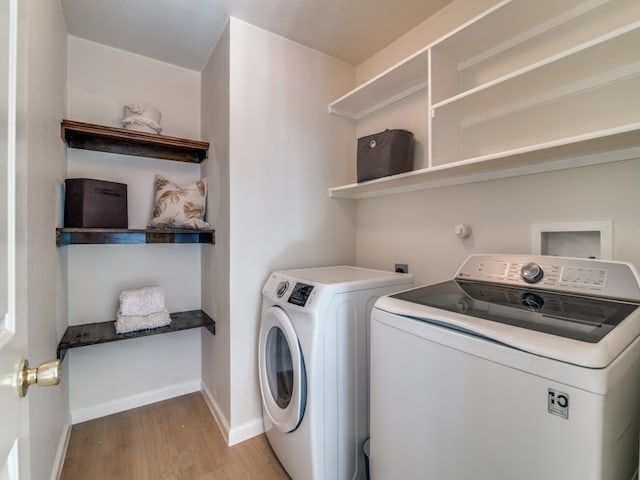 clothes washing area featuring washing machine and dryer and light wood-type flooring