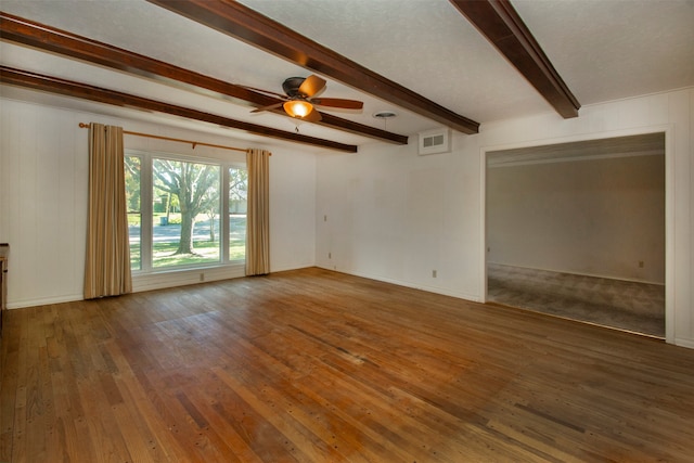 empty room featuring ceiling fan, beam ceiling, and dark wood-type flooring