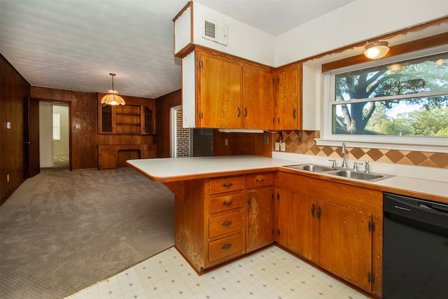 kitchen featuring kitchen peninsula, backsplash, sink, pendant lighting, and black dishwasher