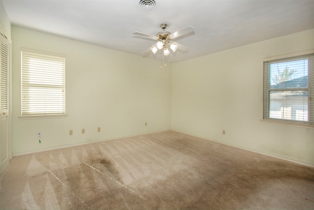 carpeted spare room featuring ceiling fan