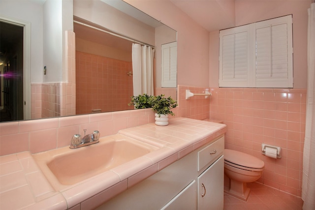 bathroom with tile patterned floors, vanity, tile walls, and toilet