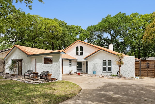 mediterranean / spanish-style home with a patio and a front lawn